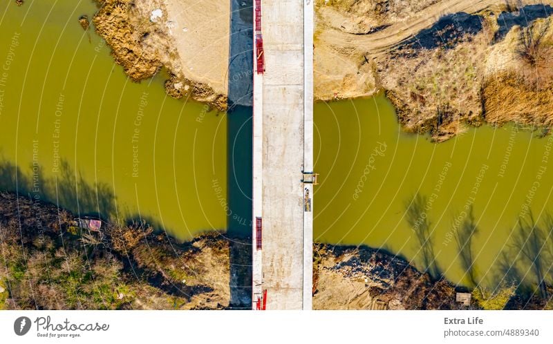 Luftaufnahme der im Bau befindlichen Straße über den Fluss, Bau der Brücke oben quer Antenne Architektur Basis Strahl Baustelle Zement Tiefbau Beton