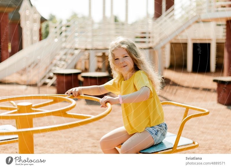 Ein charmantes kleines Mädchen geht im Park spazieren und schwingt auf einer Schaukel. Glückliche Kindheit, Spielzeit Karussell pendeln wenig Spaß niedlich