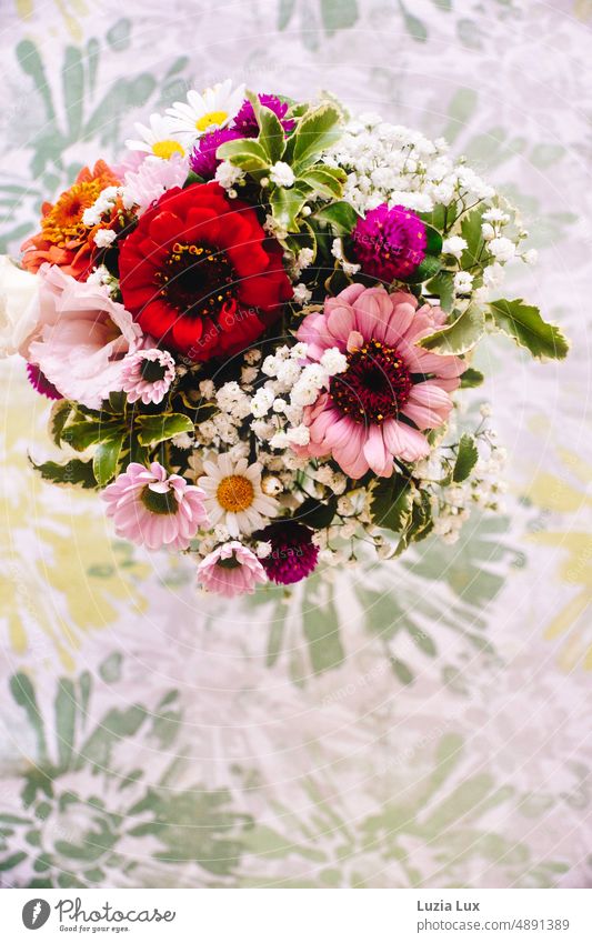 Sommerblumenstrauß, die Blüten schon verblühend. Auf einer gemusterten Tischdecke von oben fotografiert. Blumenstrauß Strauß verblüht welkend schön bunt rosa