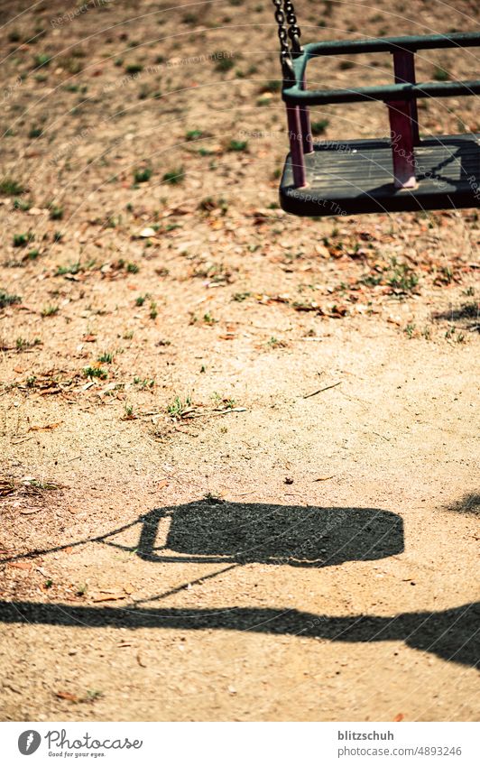 Die Hitze lässt die Schaukel leer schaukeln spielplatz hitze verwaist trocken spielen schatten kinderschaukel Spielen Kindheit Kinderspiel Bewegung Kleinkind