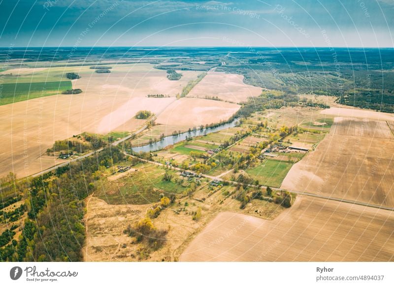 Wassiljowka, Bezirk Dobrusch, Region Gomel, Belarus. Luftaufnahme eines kleinen Dorfes mit Holzhäusern am Frühlingstag. Schöne ländliche Landschaft in der Vogelperspektive