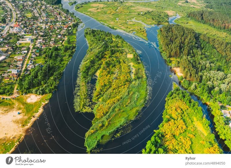 Aerial View of Summer River Landschaft in sonnigen Sommertag. Top View of Beautiful European Nature From High Attitude In Summer Season. Drone Ansicht. Vogelperspektive Ansicht. Kleine Stadt oder Dorf und natürlichen Fluss Insel