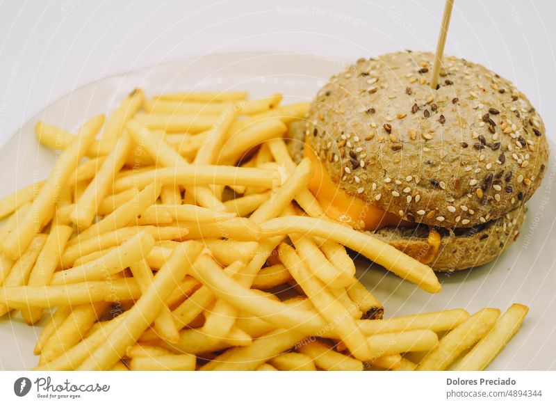 Ein Cheeseburger mit Pommes frites, ideal für ein Kindermenü Amerikaner Hintergrund Rindfleisch Brot Brötchen Burger Käse klassisch Nahaufnahme lecker Diät