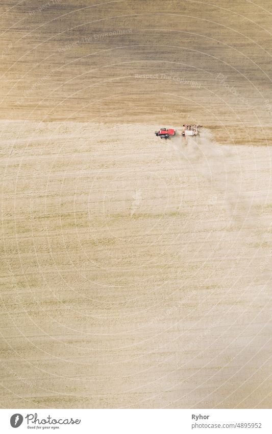 Luftaufnahme. Traktor mit Sämaschine Aussaat der Samen für Kulturen im Frühjahr Saison. Beginn der landwirtschaftlichen Frühjahrssaison. Landschaft auf dem Lande Feld Landschaft. Natürliche ländliche Hintergrund