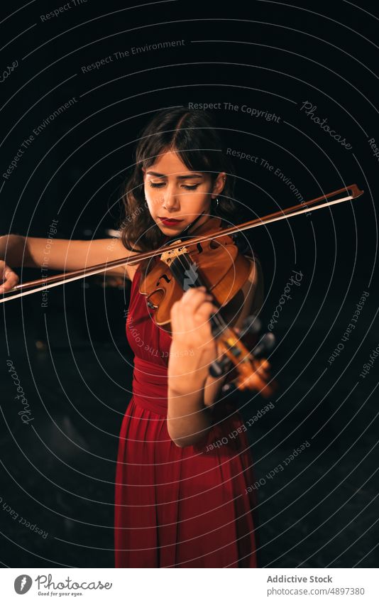 Musikerin spielt Geige auf der Bühne Frau spielen Konzert Schauplatz ausführen Theater dunkel Augen geschlossen Instrument Klang Melodie unterhalten üben