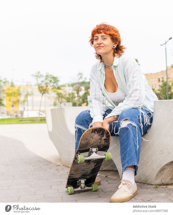 Frau mit Skateboard auf der Straße Skateplatz Skateboarderin Hobby sportlich Sport Zeitvertreib Freizeit urban Inhalt Aktivität lässig Jeanshose attraktiv