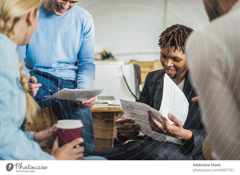 Mitarbeiter mit Dokumenten im Meeting Kollege Papierkram Schriftstück Teamwork Büro Business Projekt kooperieren Menschengruppe Afroamerikaner schwarz ethnisch