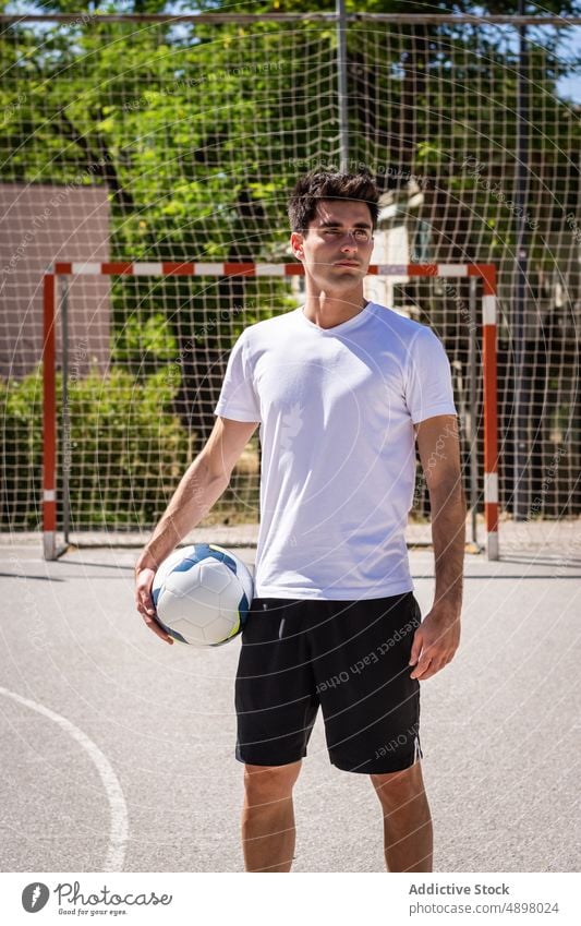 Junger Fußballspieler mit Blick in die Ferne männlich jung Spieler ernst Ball praktizieren Athlet Spielen Sport Fitness Hobby Gericht Tor Konkurrenz Netz