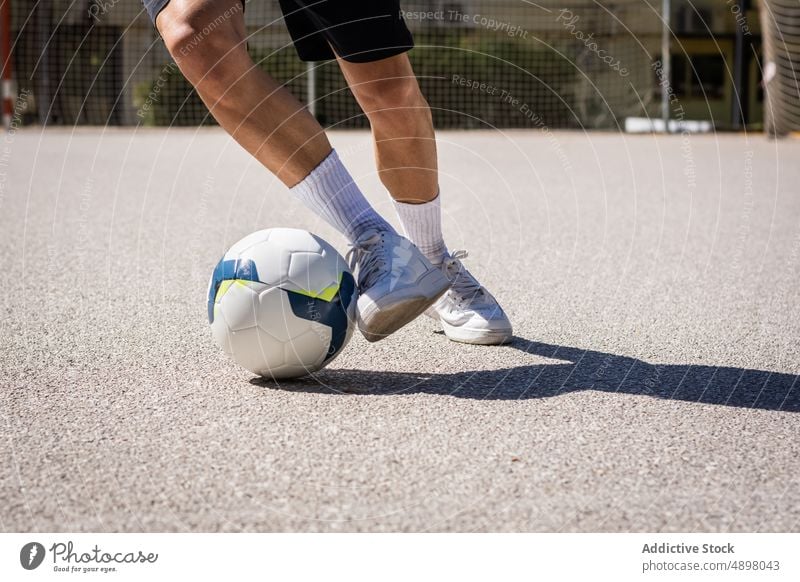 Anonymer Mann mit Bein auf Fußball männlich Athlet Sport Schuh Kniestrümpfe Spielen Sportler Spieler Konkurrenz Ball Fußballspieler Sportkleidung Fitness Shorts