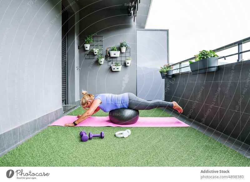 Ältere Frau in Sportkleidung balanciert auf Fit-Ball Senior Pilates Gleichgewicht Übung Training sportlich Fitness Körper Unterlage Gesundheit Lifestyle