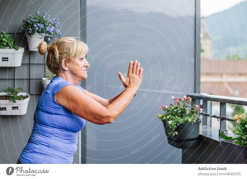 Fokussierte ältere Frau, die mit gefassten Händen Yoga praktiziert Senior praktizieren Hände gefaltet Übung aktiv passen Flexibilität Wegsehen Sportbekleidung