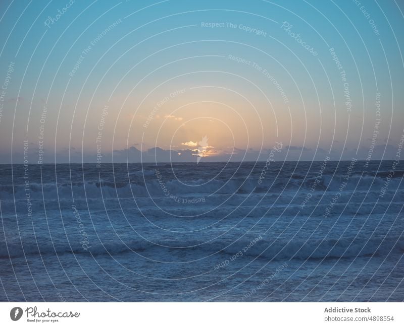 Schaumige Meereswellen rollen bei Sonnenuntergang am Strand winken Absturz schäumen Bewegung Küste Kraft Natur Meereslandschaft stürmisch platschen Unwetter