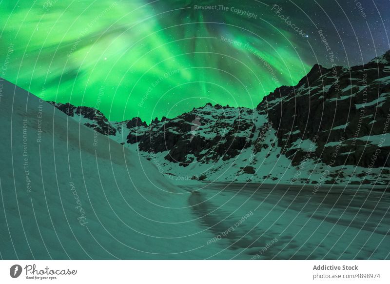 Steile Schneeberge unter Sternenhimmel und Nordlicht Klippe Felsen Nacht Landschaft Insel glühen Ambitus nördlich polar Norden Natur Stein malerisch