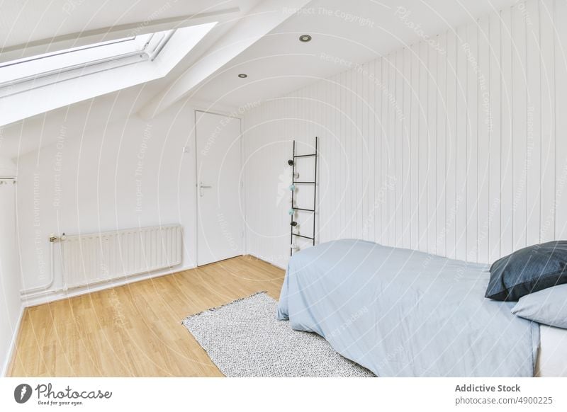 Bequemes Bett mit weißen Wänden neben einem Heizkörper Schlafzimmer Appartement gemütlich Tür Möbel Raum im Innenbereich Design Haus elegant Eingang Anwesen