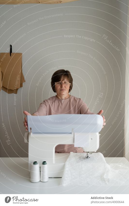 Schneiderin beim Nähen an der Maschine im Atelier Näherin Damenschneiderin Nähmaschine nähen Gewebe Textil Arbeit Werkstatt Herstellung Vorrichtung Werkzeug