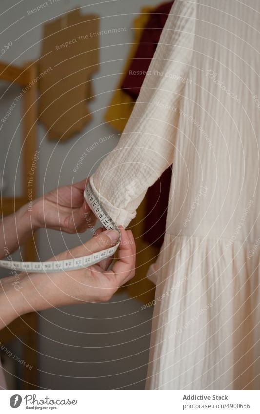 Näherin misst Ärmel eines weißen Kleides messen Hülse weißes Kleid Klebeband Atelier handgefertigt Kleinunternehmen Beruf professionell Handwerk Designer