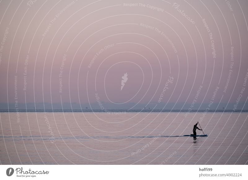 mit dem SUB bei Sonnenuntergang auf dem Meer Standuppaddling SUP ruhiges Wasser Sommer Abendsonne Abenddämmerung Morgensonne Morgendämmerung Sonnenlicht