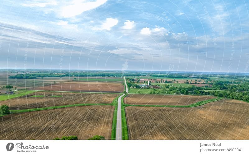 Ländliche Landstraße führt zum Horizont im ländlichen Wisconsin Frühling Amerikaner Natur Wiese Hintergrund Boden Ackerbau Sommer Dröhnen Straße Baum Wachstum