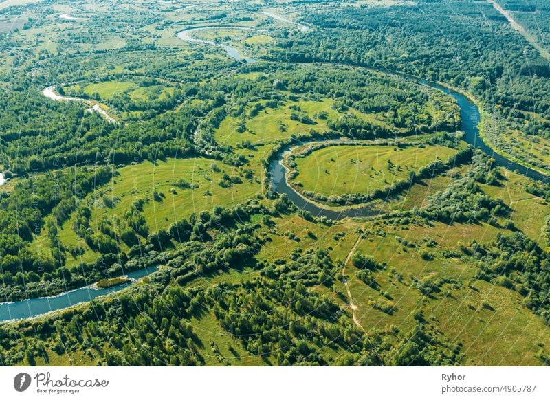 Luftaufnahme Grüner Wald Wälder und Flusslandschaft in sonnigen Sommertag. Top View of Beautiful European Nature From High Attitude In Summer Season. Drone Ansicht. Vogelperspektive Ansicht