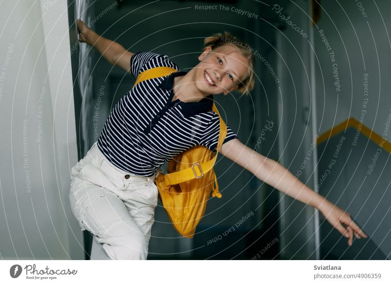 Ein fröhliches Teenager-Mädchen mit Rucksack und Mappe eilt zur Schule. back to school, das Konzept von Lernen und Bildung Schüler Lächeln Gymnasium