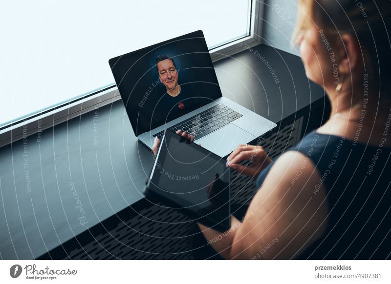 Geschäftsfrau mit Business-Videoanruf auf Laptop im Büro. Reife, vielbeschäftigte Frau, die aus der Ferne vom Büro aus arbeitet. Weiblicher Manager mit digitalen Geräten. Fernkommunikation. Videoanruf. Fernarbeit
