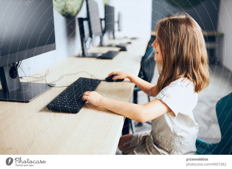 Kind lernt im Klassenzimmer in der Grundschule den Umgang mit Technologie. Schülerin benutzt Computer im Informatikunterricht der Grundschule. Zurück zur Schule