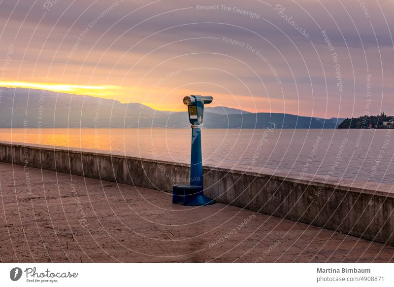 Sonnenaufgang über dem Gardasee, Ferngläser warten auf Touristen, um einen Blick über den See zu werfen Salo italienischer gardasee Spiegelglas Fernglas