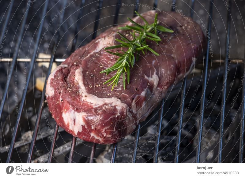 Rohes Steak mit Rosmarin auf dem Grill Rauch Fett roh Rost Fleisch Grillen BBQ Essen Kochen gegrillt Feuer Flamme gerÃ¶stet Hintergrund Nahaufnahme Mahlzeit