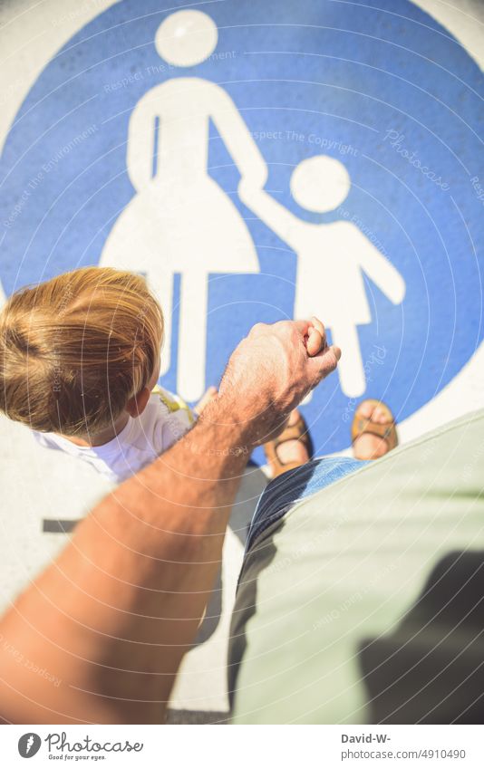 Vater und Kind Hand in Hand durch die Fußgängerzone Hände festhalten Vertrauen zusammenhalt aufsichtspflicht Familie Eltern Papa Zeichen Schild