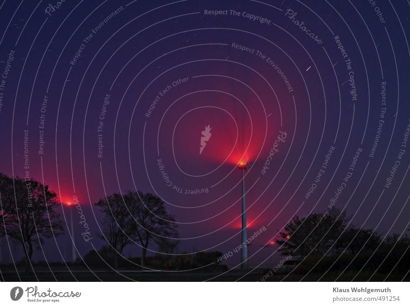 In dunstiger Nachtluft, erscheint die Beleuchtung der Windkraftanlagen besonders eindrucksvoll.Rote Lichter und dunkelblauer Himmel wirken interessant.