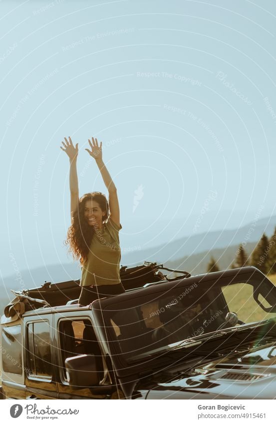 Junge Frau genießt die Freiheit im Geländewagen an einem sonnigen Tag Glück Lächeln schön Straße Laufwerk jung Fahrzeug PKW Fröhlichkeit Freude Spaß Auto