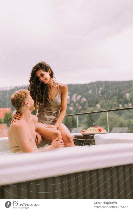 Junges Paar genießt im Freien Whirlpool im Urlaub Liebe Frau jung Glück Sommer schön Feiertage Schaumblase romantisch Wohlbefinden Wellness Mann Resort Bad