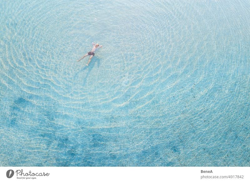 Mann entspannt sich im kristallklaren Wasser Antenne aqua Baden Bucht Strand schön blau Windstille übersichtlich Küste Küstenstreifen Küstenlinie Kristalle