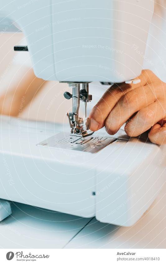 Close up Frau mit einer Nähmaschine näht wiederverwendet Stoff aus alten Denim Kleidung. Wiederverwendung alter Stoffe für neue Kleidung, Nachhaltigkeit. Alte Menschen neues Hobby zu Hause, Senioren geistige Aktivität und Arbeit