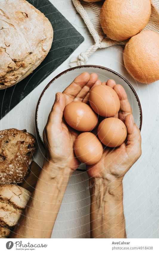 Alte Hasen bereiten eine biologische und gesunde Mahlzeit mit Sauerteigbrot, Eiern und Fruchtsaft zu. Neue Gewohnheiten, rustikales Ambiente, sich selbst versorgen. Konzept für Bäckerei und Küche. Bio echte Lebensmittel