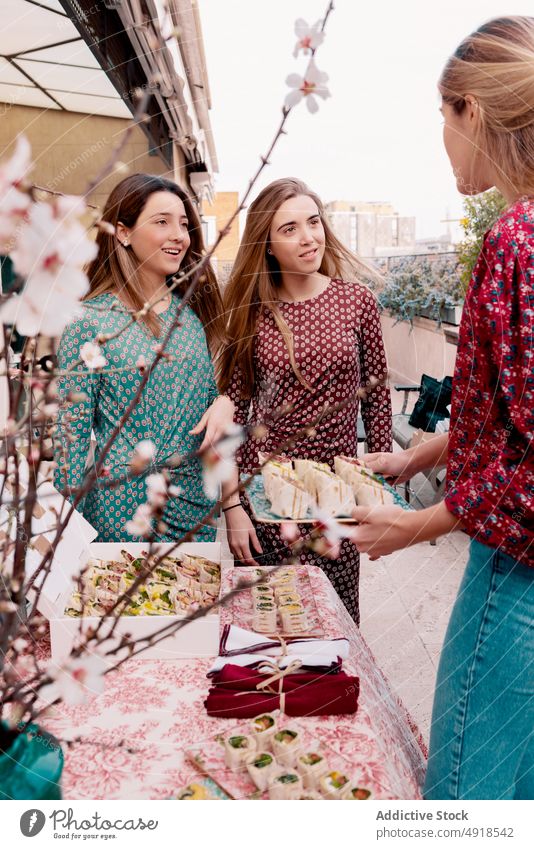 Frauen mit Tortillabrötchen auf der Terrasse Freund Tisch Festessen rollen Amuse-Gueule dienen Lebensmittel Talkrunde Sakura Ast Blume Bonden Menschengruppe