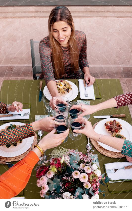 Frauen stoßen auf der Terrasse mit Weingläsern an Klirren Weinglas Freund Zuprosten jubelt feiern trinken Sitzung Wiedersehen Unternehmen Salatbeilage