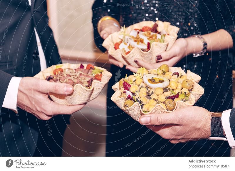 Anonyme Freunde mit Salaten an der Wand stehend Menschengruppe Salatbeilage Abendessen Mahlzeit Speise Tortilla Schalen & Schüsseln Lebensmittel Restaurant