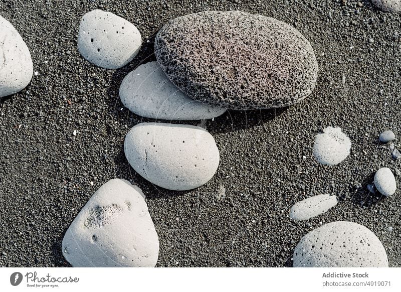 Verschiedene Kieselsteine am schwarzen Sandstrand im Sonnenlicht Stein Strand Asche vulkanisch Meeresufer Natur Küste Mineral Geologie Form Felsen Island