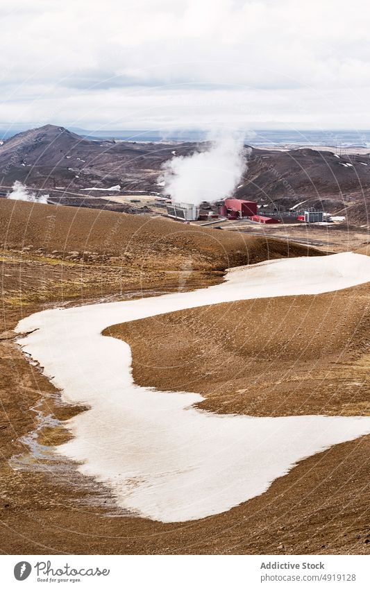 Trockenes vulkanisches Terrain vor bewölktem Himmel an einem Wintertag Hügel Tal Landschaft Natur Verdunstung Schnee Berge u. Gebirge malerisch Feld Gras