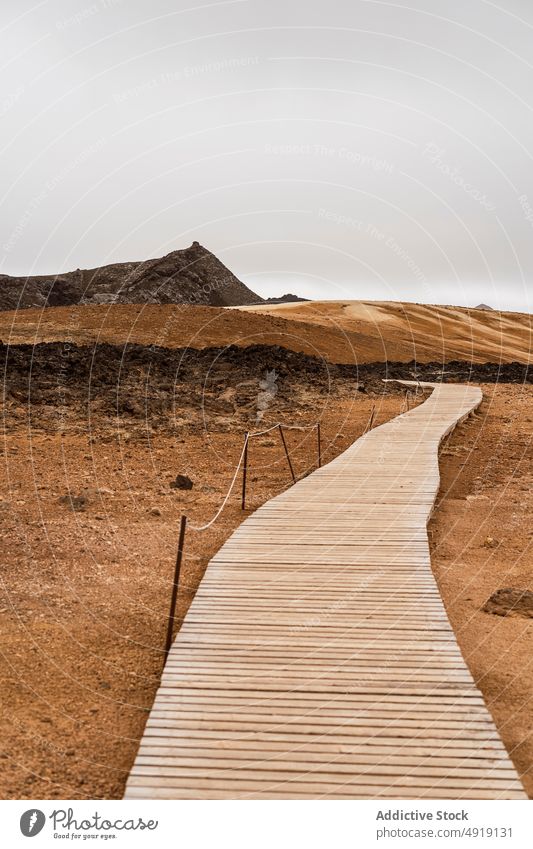 Leere Uferpromenade in vulkanischem Tal unter bewölktem Himmel Weg Berge u. Gebirge Promenade Natur Hochland malerisch friedlich Kamm Formation leer niemand