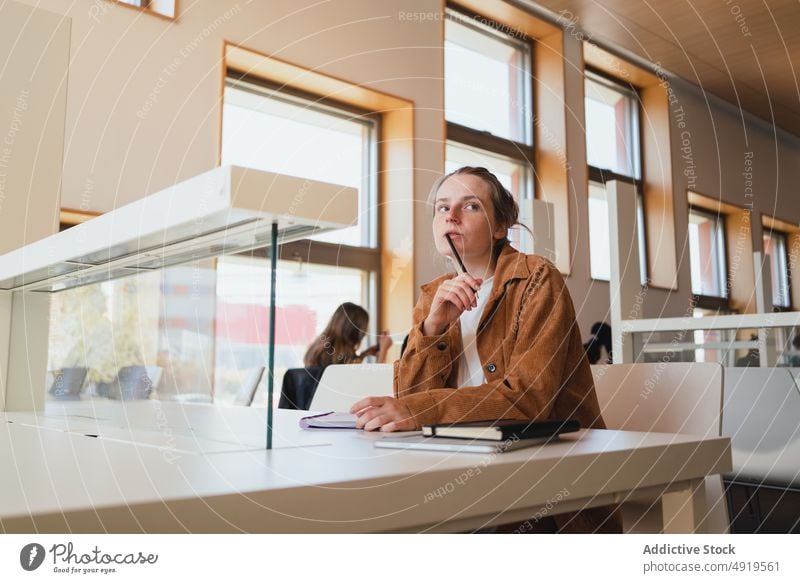 Nachdenkliche Frau studiert in der Bibliothek Schüler Denken Hausaufgabe lernen nachdenklich Universität Anweisung Bildung jung besinnlich Hochschule