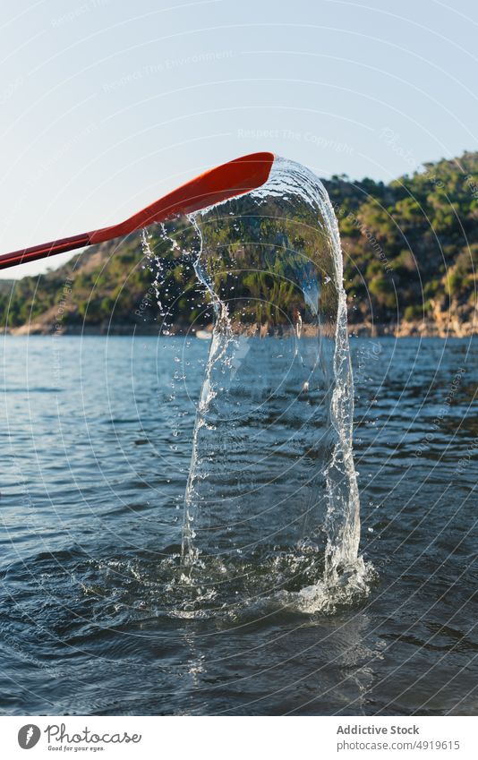 Paddeln mit plätscherndem Wasser im See platschen Natur Küste Wald Baum Ufer Seeufer Fluss Sommer Waldgebiet Blauer Himmel malerisch Umwelt Szene Gerät Vorrat