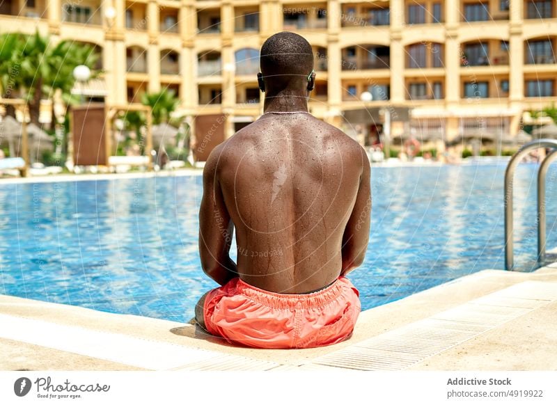 Schwarzer Mann im Schwimmbad ruhen schwimmen Erholung Schwimmsport Pool Beckenrand Kälte Zeitvertreib Resort aqua ohne Hemd passen ernst Figur Windstille