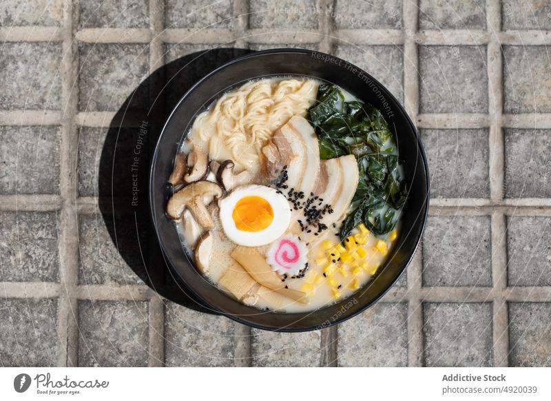 Leckere Ramen auf dem Bürgersteig serviert Japanisch Nudel traditionell Pilz Kultur Speise Straßenbelag Straßenessen Ei Bestandteil Brühe Laufsteg Sonnenlicht