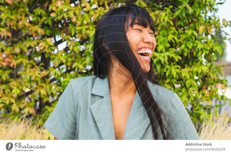 Glückliche asiatische Frau im Park Lachen Buchse üppig (Wuchs) Wochenende Stil Sommer tagsüber ethnisch jung heiter sorgenfrei Augen geschlossen Optimist Witz