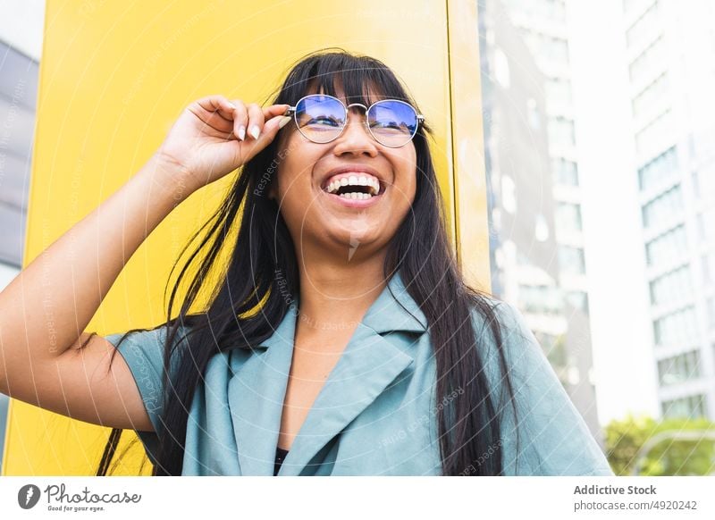 Stilvolle ethnische Frau, die eine Brille verstellt Lächeln Straße ausrichten Glück urban Wochenende Vorschein jung asiatisch ruhen froh heiter zufrieden