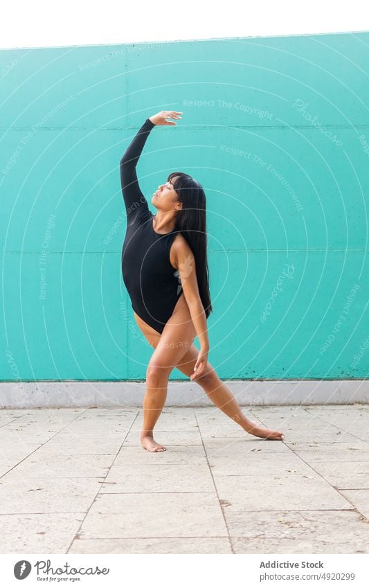 Asiatische Ballerina tanzt barfuß auf der Straße Frau Tanzen Straßenbelag Anmut Gleichgewicht ausführen Wand jung ethnisch asiatisch Lächeln Augen geschlossen