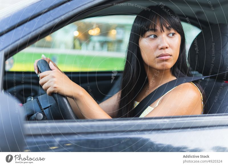 Ethnische Frau fährt Auto in der Stadt Fahrer PKW Straße Sommer Park Wochenende urban Lenkrad Arbeitsweg jung ethnisch asiatisch Fahrzeug Verkehr Automobil