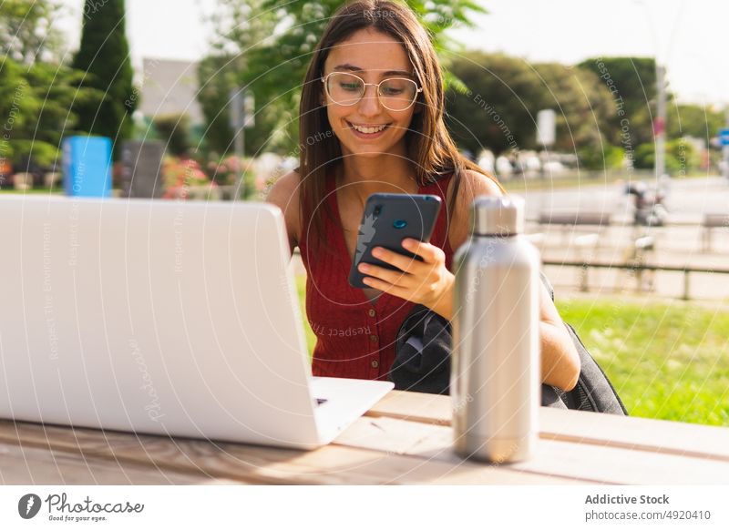 Frau macht Online-Zahlung auf der Straße Smartphone Kreditkarte bezahlen Kauf Laptop online e-Commerce Computer Transaktion bargeldlos Internet benutzend